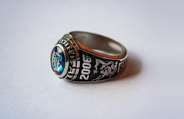 A class ring on display with a grey background.